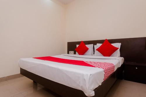 a bedroom with a large bed with red pillows at Hotel O Diplomat in Sopāra