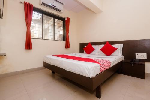 a bedroom with a large bed with red pillows at Hotel O Diplomat in Sopāra