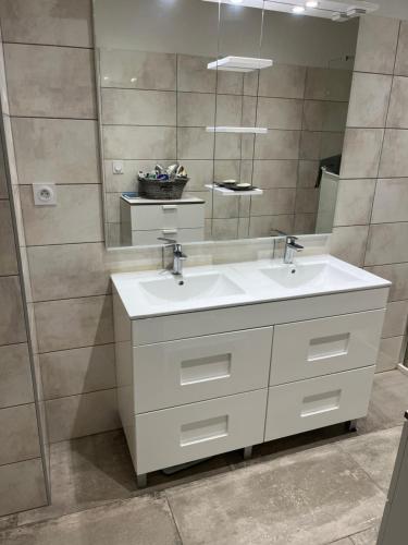 une salle de bain avec un lavabo blanc et un miroir dans l'établissement Chez lili, à Ghisonaccia