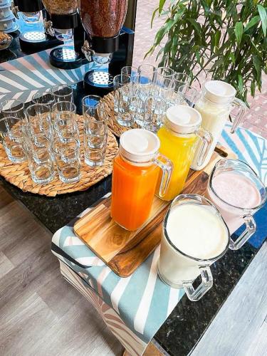 a table with glasses and jars on top of it at Alcazar de Oviedo by EE Hoteles in Medellín
