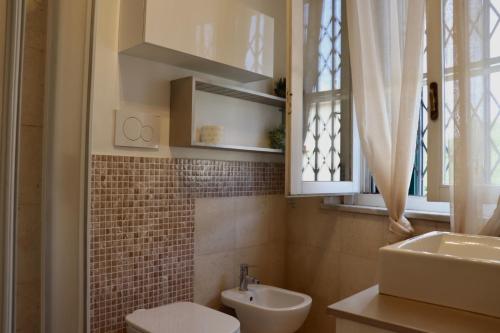 a bathroom with a sink and a toilet and a window at Il Glicine in Livorno