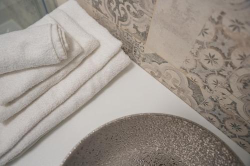 a bathroom with two towels and a sink at Pool and Breakfast Apartments Villa Maro in Novalja