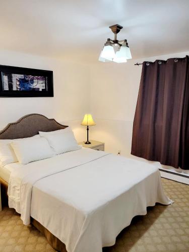 a bedroom with a large white bed and a window at Excellence vacation home in St. John's