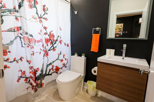 a bathroom with a toilet and a shower curtain at Chill in Style Anime Themed Escape in Philadelphia