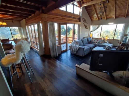 una sala de estar con un sofá y una mesa en Casa Suiza, vistas panorámicas al lago, ciudad y montañas !!, en San Carlos de Bariloche