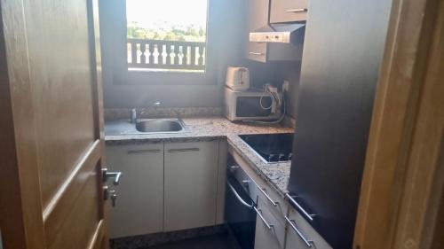 a small kitchen with a sink and a microwave at Appartement avec vue sur l'Atlas et piscine in Marrakech