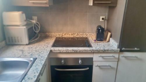 a small kitchen with a sink and a microwave at Appartement avec vue sur l'Atlas et piscine in Marrakech