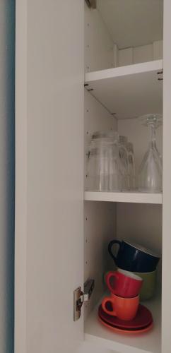 a cupboard with some bowls and other dishes in it at Casa Polixeni - Da e Nònne in Carloforte