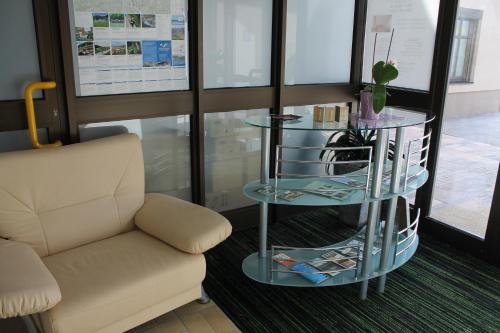 a waiting room with a chair and a glass table at Post Hostel For Youth, Students and Pilgrims in Lavamünd