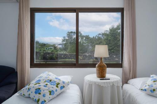 a room with a window and a table with a lamp at Casa das Hortências by Azoresrent in Farroupo