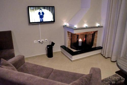 a living room with a fireplace and a tv at Cavos Fokidos in Chiliadou