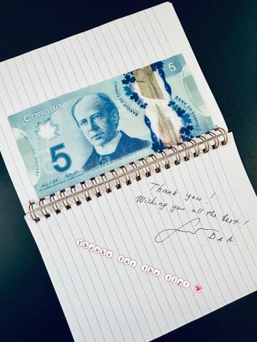 a page of a notebook with a dollar bill on it at Scorpion Hiuse Langley ROOM B in Langley