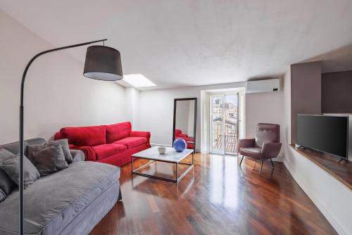 a living room with a red couch and a tv at Casa Dona - Essenza in Catania