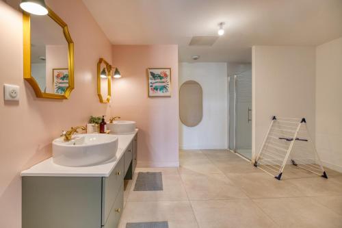 a bathroom with two sinks and a mirror at Coteaux en Vue in Aureville