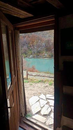 an open door with a view of a lake at Cabaña el ojo de Horus in El Chalten
