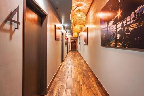 a hallway with wooden floors and paintings on the walls at Nomads Hotel in San Clemente