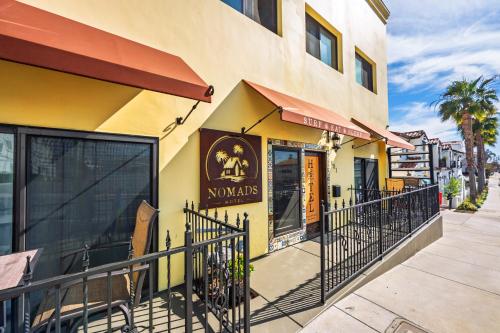 a yellow building with a fence next to a sidewalk at Nomads Hotel in San Clemente