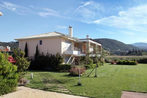 a house with a lawn in front of it at Cavos Fokidos in Chiliadou