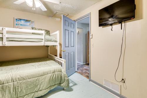 a bedroom with bunk beds and a flat screen tv at 3 Mi to Dtwn Fort Wayne Home with Deck and Yard! in Fort Wayne