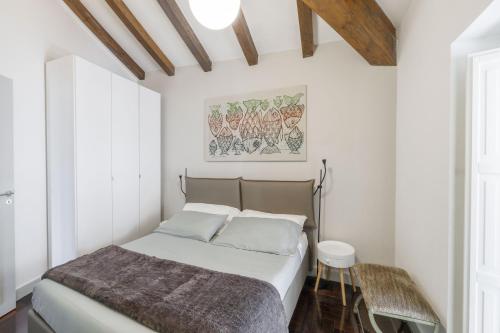 a bedroom with a bed with white walls at Casa Dona - Essenza in Catania