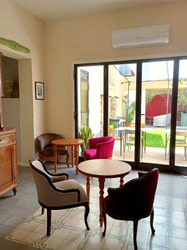 a living room with a table and chairs and a patio at Sette Fate Suites & Spa in Palermo
