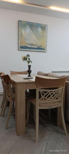 a wooden table and chairs with a vase of flowers on it at FUFA Haute standing appartment S2 center Monastir in Monastir