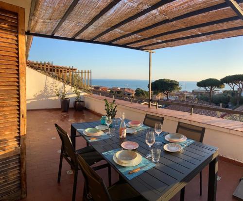 a table on a balcony with a view of the ocean at Belvedere apartment in Castiglione della Pescaia