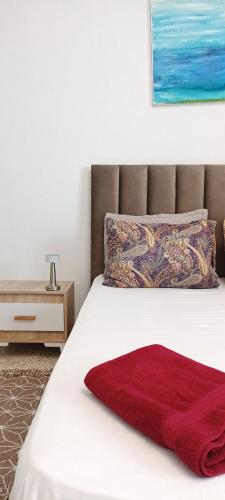 a bedroom with a bed with a red blanket on it at FUFA Haute standing appartment S2 center Monastir in Monastir
