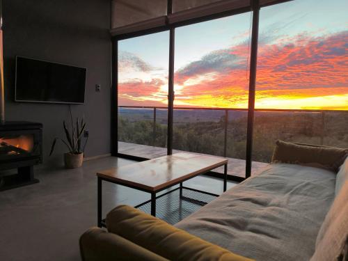 a living room with a couch and a table and a sunset at Villa Toscana I - Gran Vista y Tranquilidad in Villa Serrana