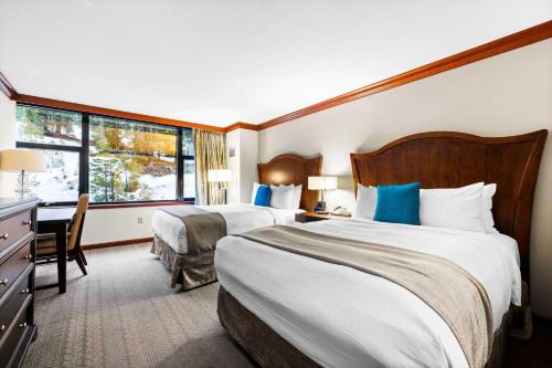 a hotel room with two beds and a desk at Everline Resort & Spa Palisades- Forest View in Olympic Valley