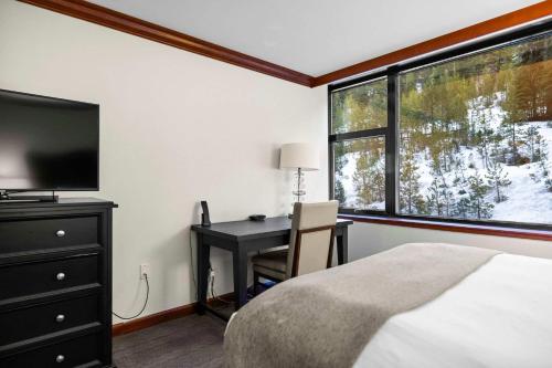a bedroom with a desk and a bed and a window at Everline Resort & Spa Palisades- Forest View in Olympic Valley