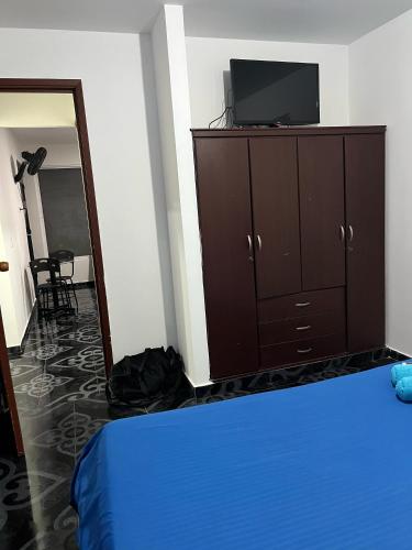 a bedroom with a bed and a dresser with a tv at Confort 13-47 in Cali