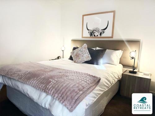 a bedroom with a bed with a bull skull on the wall at Woodland Retreat - Phillip Island in Cowes