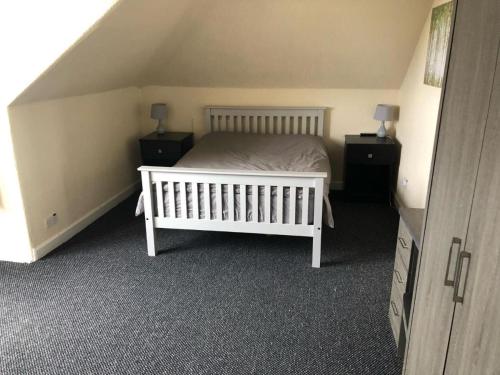 a bedroom with a white bed and two night stands at Railway Inn in Buckhaven