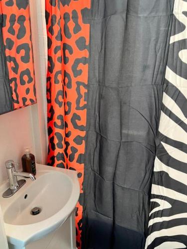 a bathroom with a sink and a shower curtain at Studio Haven in Hollywood in Los Angeles