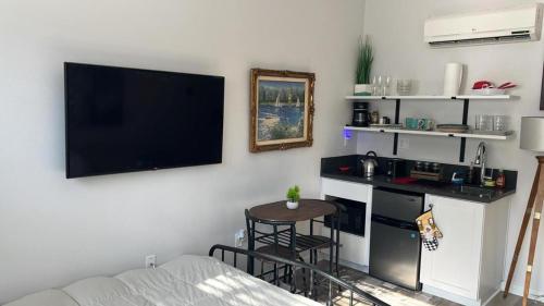 a living room with a table and a tv on the wall at Studio Haven in Hollywood in Los Angeles