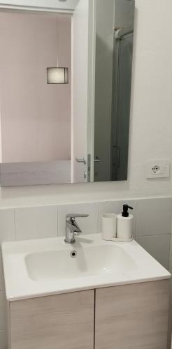 a white bathroom with a sink and a mirror at Casa Fiorenza - Da e Nònne in Carloforte