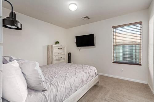 a bedroom with a bed and a tv on the wall at Beautifully Decorated HomeAvondalePrivatePool in Avondale