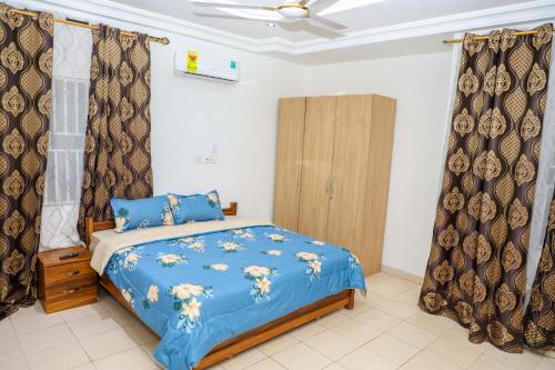 a bedroom with a blue bed and curtains at Capricorn Heights BnB 2 bedrooms Apartment at Kwabenya, Accra, Balloon Gate in Kwabenya