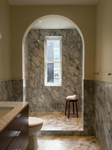 a bathroom with a toilet and a window at 3.8 Million Dollar Brownstone Newly Renovated in New York