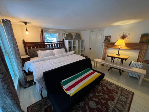 a bedroom with a bed and a table with a lamp at High Peaks Private Room #4 in a Shared House Homestay in Keene Valley