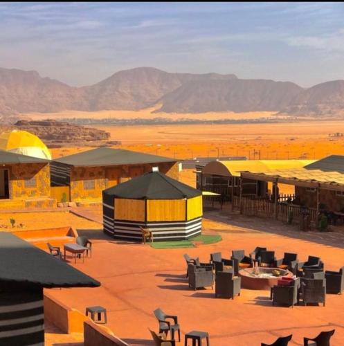 a resort in the desert with mountains in the background at Wadi rum camp hamod in Wadi Rum