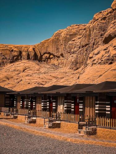 a building in front of a rocky mountain at Wadi rum camp hamod in Wadi Rum