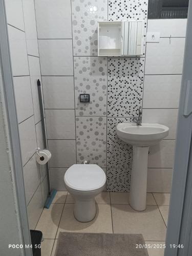 a bathroom with a toilet and a sink at Pousada santos ll, kitnet confortável com ar condicionado in Londrina