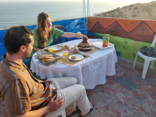 a woman sitting at a table with a man at Skb Sea House Taghazout in Taghazout