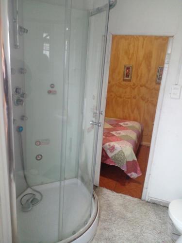 un bagno con doccia, servizi igienici e letto di Hostal Palmera a Rancagua
