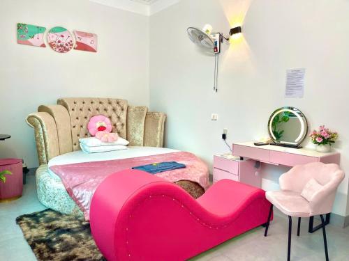 a bedroom with a pink bed and a pink chair at Nhà Nghỉ Hưng Hà in Kon Rung (1)