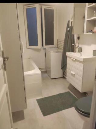 une salle de bain blanche avec un lavabo et des toilettes dans l'établissement PARIS CENTER Charming apartment - Strasbourg Saint Denis, à Paris