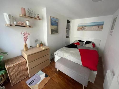 - une chambre avec un lit et une commode avec une couverture rouge dans l'établissement PARIS CENTER Charming apartment - Strasbourg Saint Denis, à Paris