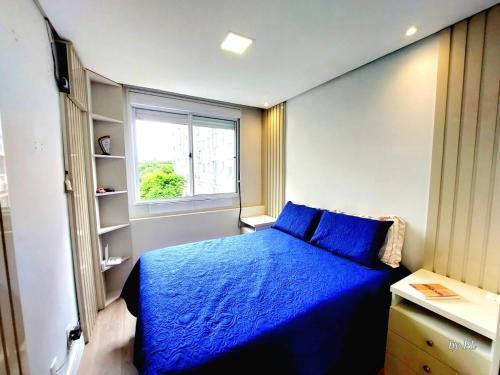 une chambre avec un lit bleu et une fenêtre dans l'établissement Xingu Reserva Ipanema, à Porto Alegre